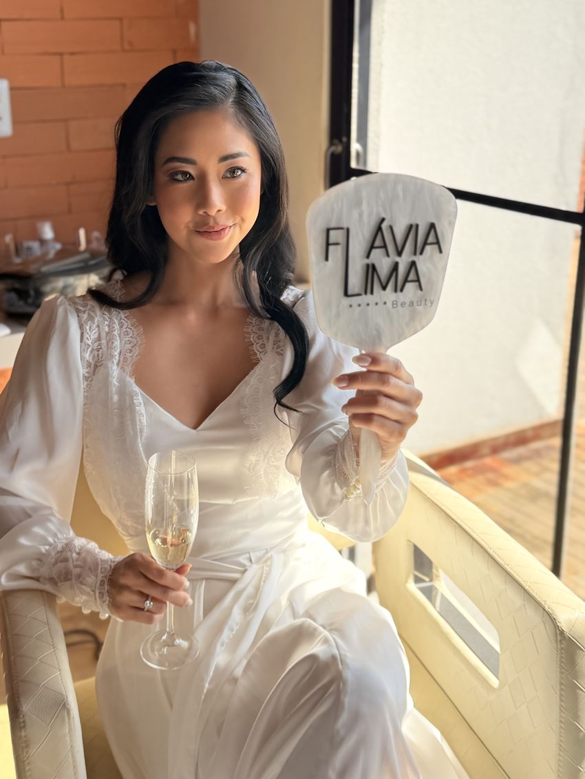 Noiva de robe segurando o espelho de mão Flávia Lima Beauty