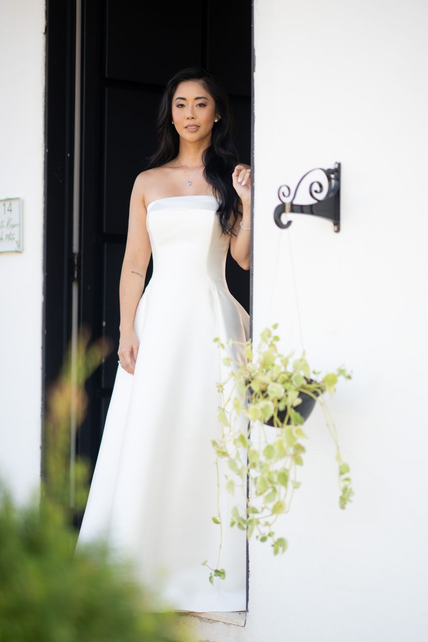 Noiva de vestido no vão da porta, retrato de corpo inteiro
