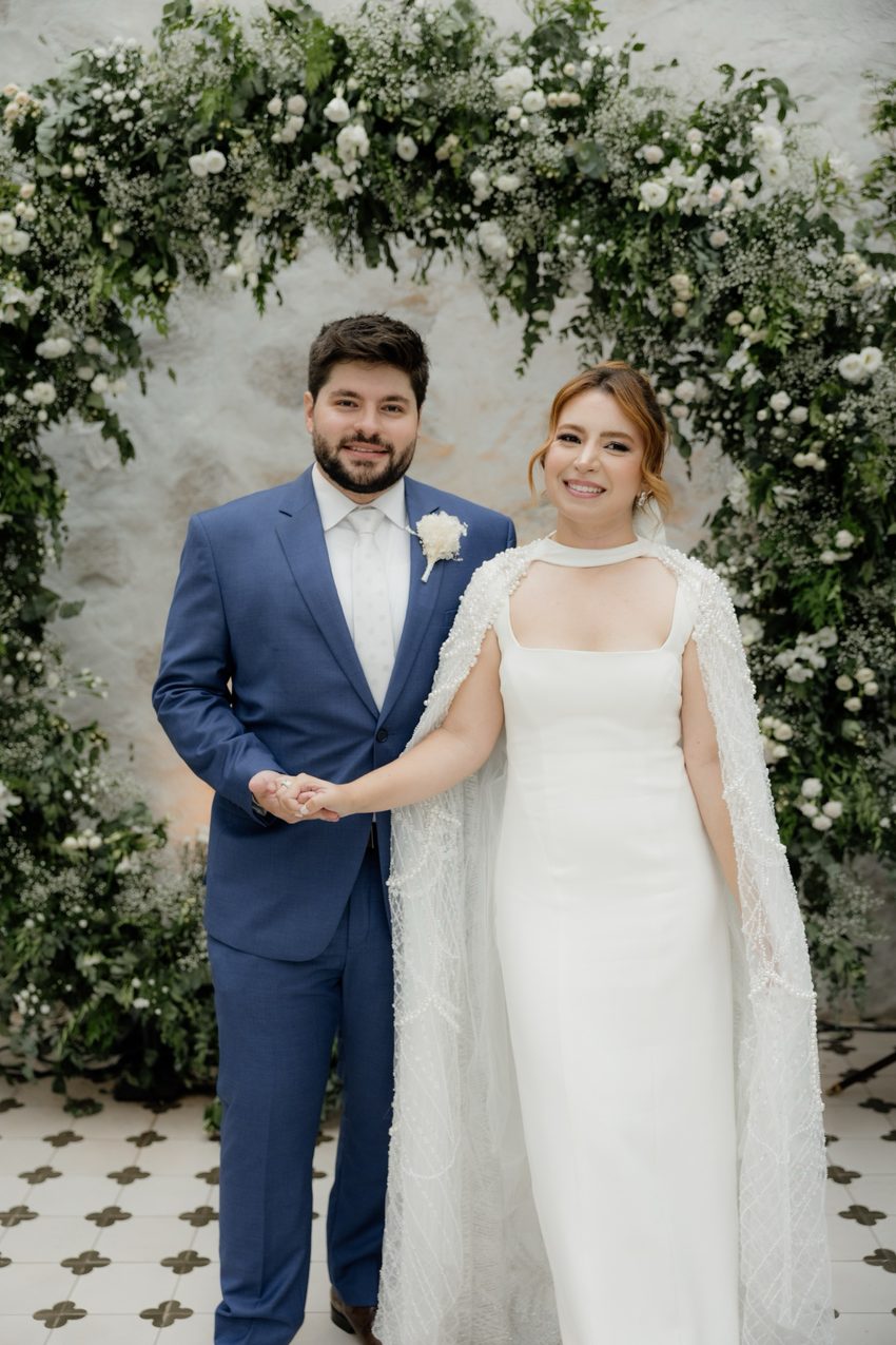 Casal no arco floral, para a câmera